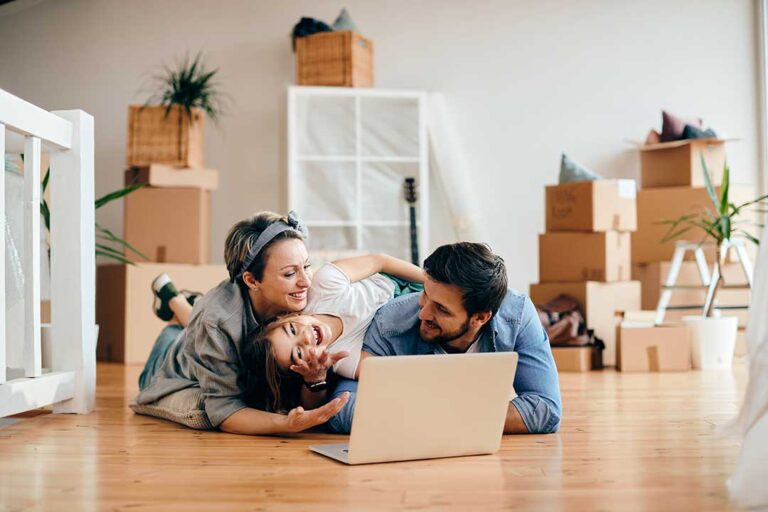 A couple reviews a home inspection report with an agent at a kitchen counter.